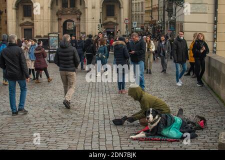 Prag, Tschechische Republik. 01-11-2020. Touristen gehen auf der Karlsbrücke über die historische Stadt in Prag. Bettler versucht, Geld von t zu sammeln Stockfoto