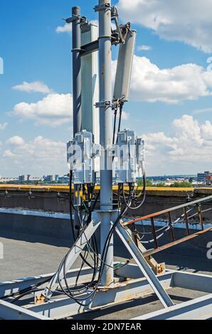 Mobilfunkbasisantennen 4G und 5G auf Flachdach Von einem Hochhaus vor dem Hintergrund des bewölkten Himmels Stockfoto
