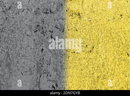Die trendigen Farben von 2021 Jahr sind grau und gelb. Strukturierter alter Putz an der Wand in zwei Farben lackiert Stockfoto