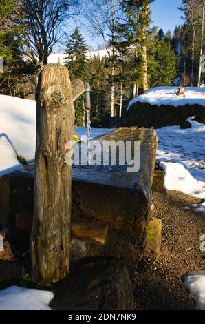 incredible winter fairy image, water gushes from a well in the forest, winter picture, running clear water on the hill Stock Photo