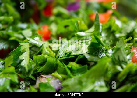 Nahaufnahme von Tabbouleh Salat mit Petersilie, Kirschtomaten, Zwiebel, Zitrone, Olivenöl und Basilikum Stockfoto