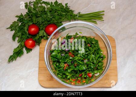 Nahaufnahme von Tabbouleh Salat mit Petersilie, Kirschtomaten, Zwiebel, Zitrone, Olivenöl und Basilikum Stockfoto