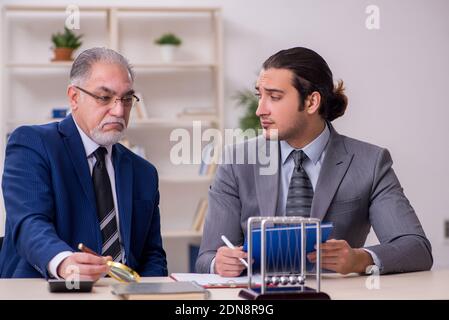 Zwei Geschäftsleute und Meditationskugeln auf dem Tisch Stockfoto