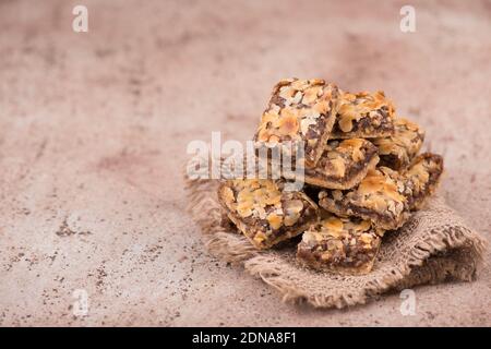 Confectioneries with nuts and chocolate, german christmas sweets, little cakes on a brown textured background, empty copy space for text Stock Photo