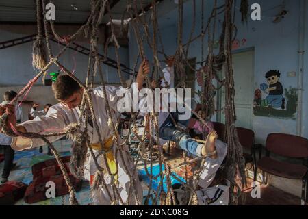 17. Dezember 2020: Bilder, die in einer Schule für Menschen mit besonderen Bedürfnissen in der Stadt Al-Jinah auf dem Land von Aleppo aufgenommen wurden, zeigen Kinder mit besonderen Bedürfnissen, die unter der Leitung des Ausbilders Wasim Stout, der einen schwarzen Gürtel in Karate trägt, im Karate ausgebildet werden. Wasim arbeitet mit Schulungen, um eine bestimmte Anzahl behinderter Kinder mit einer ähnlichen Anzahl gesunder Kinder zu integrieren, um Behinderten zu helfen, sich in die Gesellschaft zu integrieren und sich von Autismus fernzuhalten. Wasim startete sein Projekt vor sieben Jahren in der Stadt Aleppo, nachdem er von der Vision vieler Menschen mit d betroffen war Stockfoto