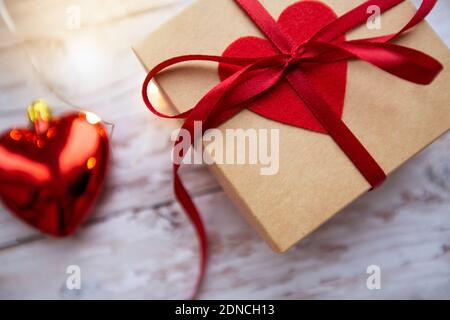 Geschenkbox mit rotem Herz auf Holzhintergrund, Valentinstag Stockfoto