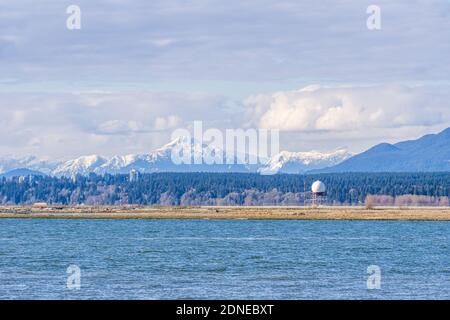 RICHMOND, KANADA - 05. APRIL 2020: Vancouver International Airport YVR mit den Coast Mountains im Hintergrund und dem Fraser River im Vordergrund Stockfoto