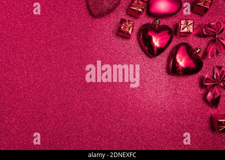 valentines day background, pink hearts and gifts on red shiny background, top view Stockfoto