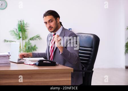 Männlicher Mitarbeiter, der Flash-Laufwerk in den Laptop einsteckt Stockfoto