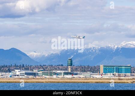 RICHMOND, KANADA - 05. APRIL 2020: Vancouver International Airport YVR mit den Coast Mountains im Hintergrund und dem Fraser River im Vordergrund Stockfoto