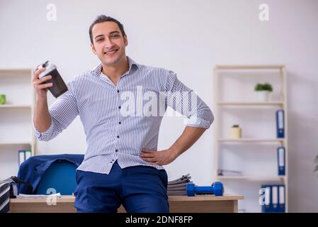 Schöner männlicher Angestellter, der Übungen im Büro macht Stockfoto