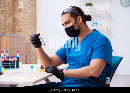 Männlicher Biochemiker, der Blutproben testet Stockfoto