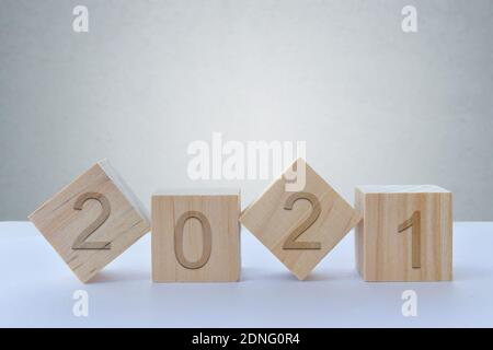 Geometrische Holzwürfel auf Tisch mit Nummern 2021, Konzept des neuen Jahres 2021, Kopierraum. Stockfoto