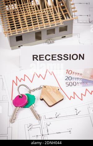 Home Schlüssel, Inschrift Rezession, Währungen Euro und Abwärtsgraphen, die Krise des Immobilienmarktes durch Coronavirus verursacht. Reduziertes Gehäuse Stockfoto