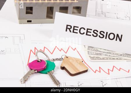 Home Schlüssel, Inschrift Rezession, Währungen Dollar und Abwärtsgraphen, die die Finanzkrise des Immobilienmarktes durch Coronavirus verursacht. Rot Stockfoto