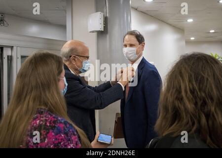 United States Senator Ron Wyden (Democrat of Oregon), right, gets a little help with his tie from United States Senator Pat Roberts (Republican of Kansas) while they wait for a train in the Senate subway at the U.S. Capitol in Washington, DC, USA, Thursday, December 17, 2020. Photo by Rod Lamkey/CNP/ABACAPRESS.COM Stock Photo