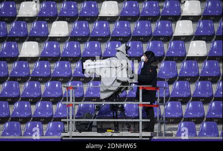 Aue, Germany. 17th Dec, 2020. Football: 2. Bundesliga, FC Erzgebirge Aue - Karlsruher SC, Matchday 12, at the Erzgebirge stadium. A cameraman stands behind his TV camera with FFP2 mask. Credit: Robert Michael/dpa-Zentralbild/dpa - IMPORTANT NOTE: In accordance with the regulations of the DFL Deutsche Fußball Liga and/or the DFB Deutscher Fußball-Bund, it is prohibited to use or have used photographs taken in the stadium and/or of the match in the form of sequence pictures and/or video-like photo series./dpa/Alamy Live News Stock Photo