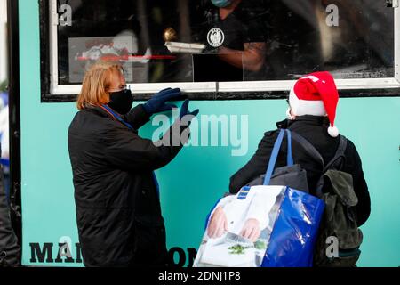 Berlin, Deutschland. Dezember 2020. Frank Zander serviert den Obdachlosen am Alexanderplatz in Mitte warme Speisen. Frank Zander und seine Familie unterstützen von Caritas und Diakonie betriebene Food Trucks für Obdachlose und Bedürftige. Aufgrund der Corona-Pandemie muss seine traditionelle Weihnachtsfeier für Obdachlose und Bedürftige im Estrel Hotel in diesem Jahr abgesagt werden. Quelle: Gerald Matzka/dpa-Zentralbild/ZB/dpa/Alamy Live News Stockfoto