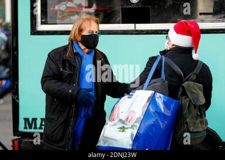 Berlin, Deutschland. Dezember 2020. Frank Zander serviert den Obdachlosen am Alexanderplatz in Mitte warme Speisen. Frank Zander und seine Familie unterstützen von Caritas und Diakonie betriebene Food Trucks für Obdachlose und Bedürftige. Aufgrund der Corona-Pandemie muss seine traditionelle Weihnachtsfeier für Obdachlose und Bedürftige im Estrel Hotel in diesem Jahr abgesagt werden. Quelle: Gerald Matzka/dpa-Zentralbild/ZB/dpa/Alamy Live News Stockfoto