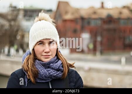 Porträt eines jungen schönen glücklich lächelnden Mädchen auf dem Hintergrund der Stadt. Wintermode, Weihnachtsferien Konzept Stockfoto