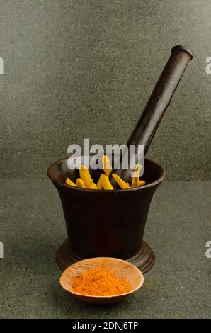 Indischer Eisenmörtel und Stößel Set mit rohem Kurkuma. Studioaufnahme Stockfoto