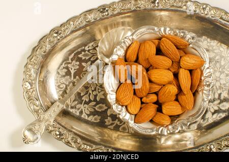 Mandeln oder Badam getrocknete Früchte in einer dekorativen Silberschale präsentiert. Studioaufnahme Stockfoto