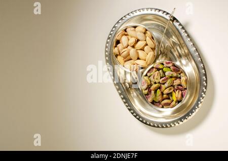 Dried Fruit Pistachio or Pista Nuts presented in silver bowls Top angle. Studio Shot Stock Photo