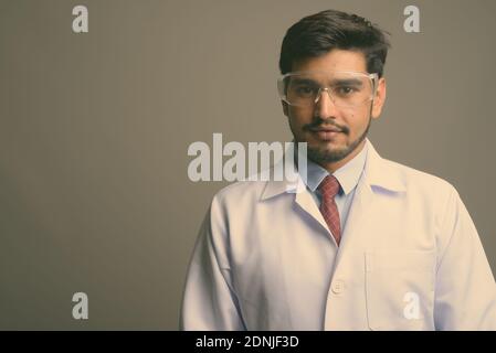 Junge gut aussehende bärtige persischen Mann Arzt trägt Schutzbrille Stockfoto