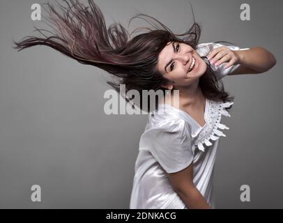 Happy young woman in night gown with hair flying in the morning Stockfoto