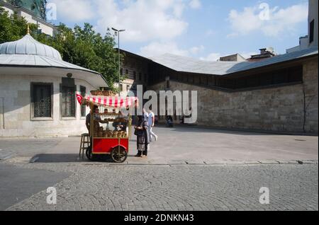 Istanbul, Türkei - September, 2018: Mann verkauft simit kreisförmigen türkischen Brot orbagel von traditionellen roten Händler auf Rädern. Teil der Fast-Food-Kultur Stockfoto