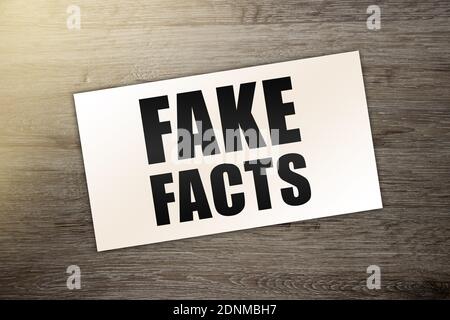 Fake News Wort auf Visitenkarte auf Holztisch. News und Geschäftskonzept. Stockfoto