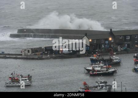 Lyme Regis, Dorset, Großbritannien. Dezember 2020. Wetter in Großbritannien. Große stürmische Wellen schlagen bei Flut an einem Morgen starker böiger Winde und Regen gegen die historische Cobb Harbour Wall bei Lyme Regis in Dorset. Bild: Graham Hunt/Alamy Live News Stockfoto