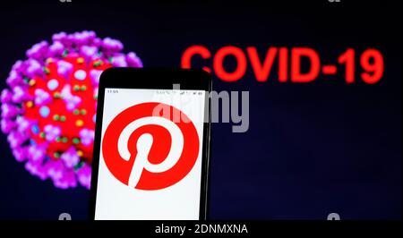 In diesem Foto Illustration Pinterest Social Media Logo ist zu sehen Angezeigt auf einem Smartphone auf dem bacgroind des Bildes von COVID-19-Virus Stockfoto