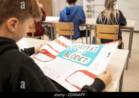 Junge in der Klasse halten Poster Stockfoto