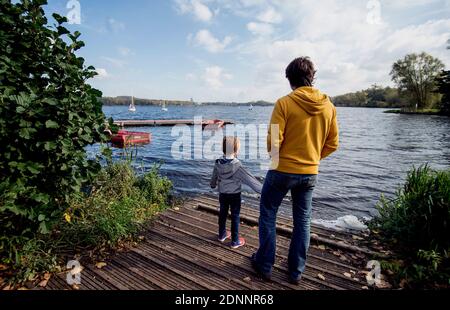 Conde-sur-L'Escaut (Nordfrankreich): Ehemaliges Bergbaugebiet von Chabaud-Latour und Bergteich. Ein Mann und ein Kind von hinten auf einem hölzernen Ponton betrachtet Stockfoto