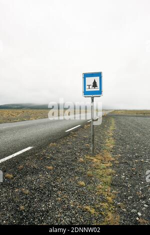 Minimal leere Island Landschaft Detail einer leeren Straße und Picknick-Parkplatz Schild ohne Menschen oder Autos unter einem trüben grauen Himmel. Stockfoto