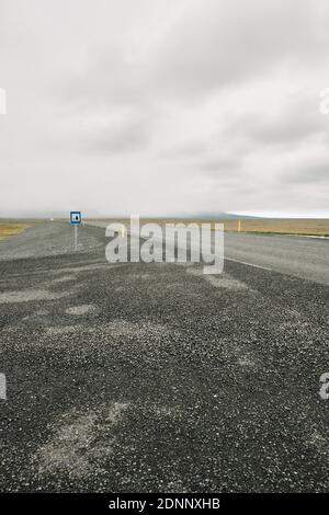 Minimal leere Island Landschaft Detail einer leeren Straße und Picknick-Parkplatz Schild unter einem flachen wolkigen grauen Himmel Stockfoto