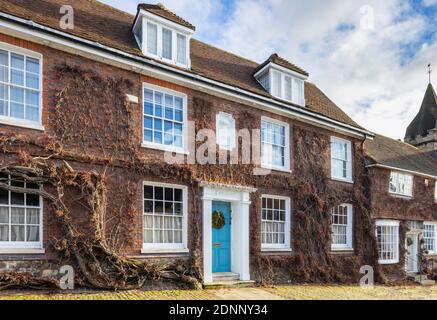 Reihenhaus im georgianischen Stil (Church Hill House) in Church Hill, Midhurst, West Sussex, im Winter mit einem Weihnachtskranz an der blauen Haustür Stockfoto