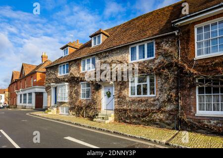 Reihenhaus im georgianischen Stil (Church Hill House) in Church Hill, Midhurst, West Sussex, im Winter mit einem Weihnachtskranz an der blauen Haustür Stockfoto