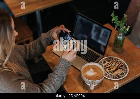 Woman taking photo in cafe Stock Photo