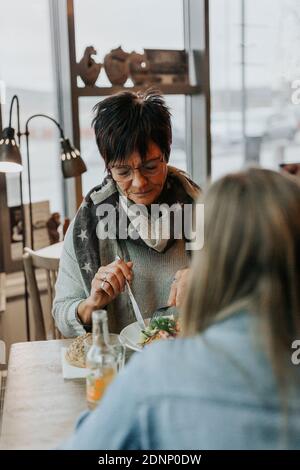 Frau, die im Café zu Abend gegessen hat Stockfoto
