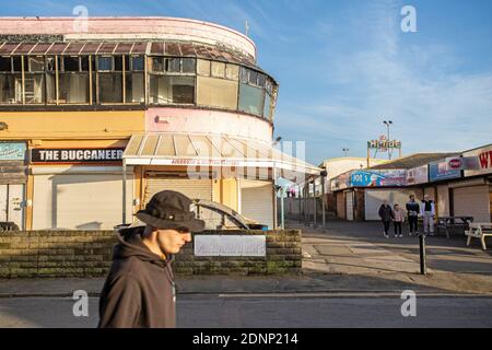 GROSSBRITANNIEN / Wales / Coney Beach Porthcawl / Leute, die an den Arkaden und dem Vergnügungspark am Meer vorbeikommen, wo Geschäfte und Stände geschlossen sind. Stockfoto