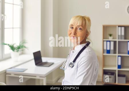 Nahaufnahme Porträt von älteren müde Ärztin Blick auf die Kamera, während im medizinischen Büro stehen. Stockfoto