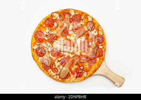 Leckere Pizza würziger Pfeffer auf einem Holzteller serviert, Zutaten Signature-Sauce, Mozzarella-Käse, Pepperoni, eingelegte Gurke, bulgarischer Pfeffer, rote Zwiebel, Chili-Pfeffer. Pizzeria Werbeplakat. Stockfoto