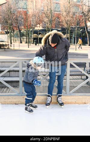 Vater unterrichtet Sohn Eislaufen Stockfoto