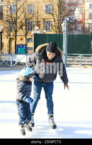 Vater unterrichtet Sohn Eislaufen Stockfoto