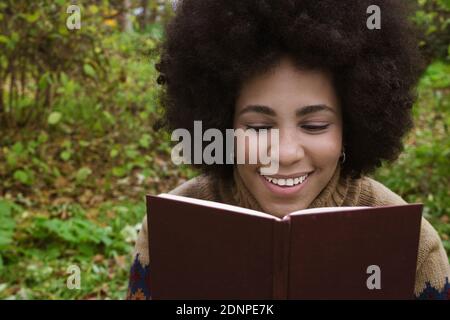 Ein kubanisches Mädchen genießt das Lesen im Park Stockfoto