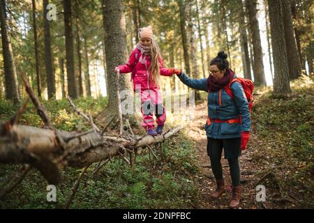 Mutter mit Tochter, die durch den Wald geht Stockfoto