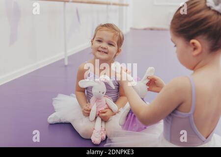 Happy Little cute girl trägt Tutu und Trikot lachen freudig, genießen Ballettunterricht an der Tanzschule. Liebenswert kleine Ballerinas Ruhe nach ex Stockfoto