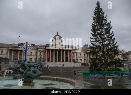 London, Großbritannien, 18. Dezember 2020. Die riesige Menorah erleuchtete für Chanukah, das jüdische Lichterfest, auf dem Trafalgar Square. Weiter oben das Weihnachtsbaumgeschenk der Osloer nach London .Paul Quezada-Neiman/Alamy Live News Stockfoto